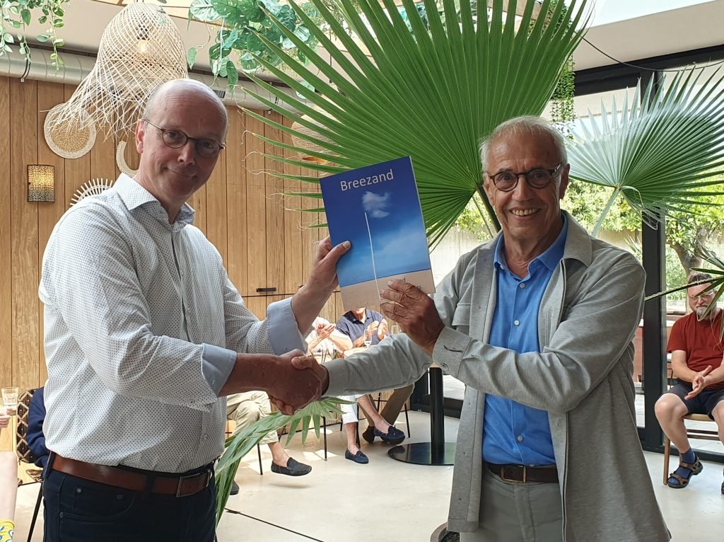 Wethouder de Vissers ontvangt het boek van Nico Koole